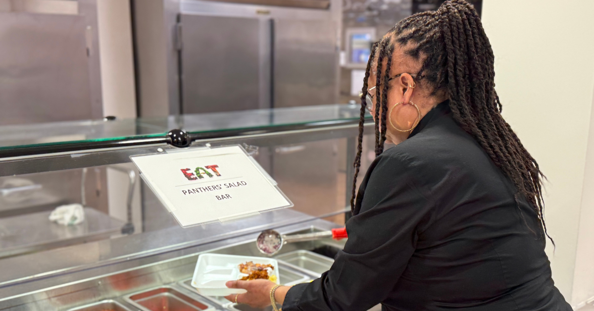 woman grabbing food from cafeteria